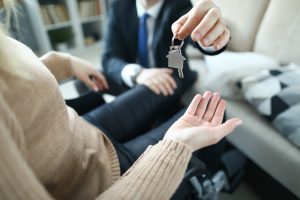agent giving keys of apartment to new owner in disabled carriage after signed lease agreement